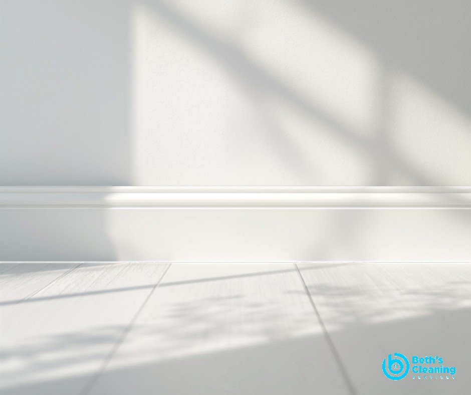 Clean white baseboards and a wall vent in a bright room