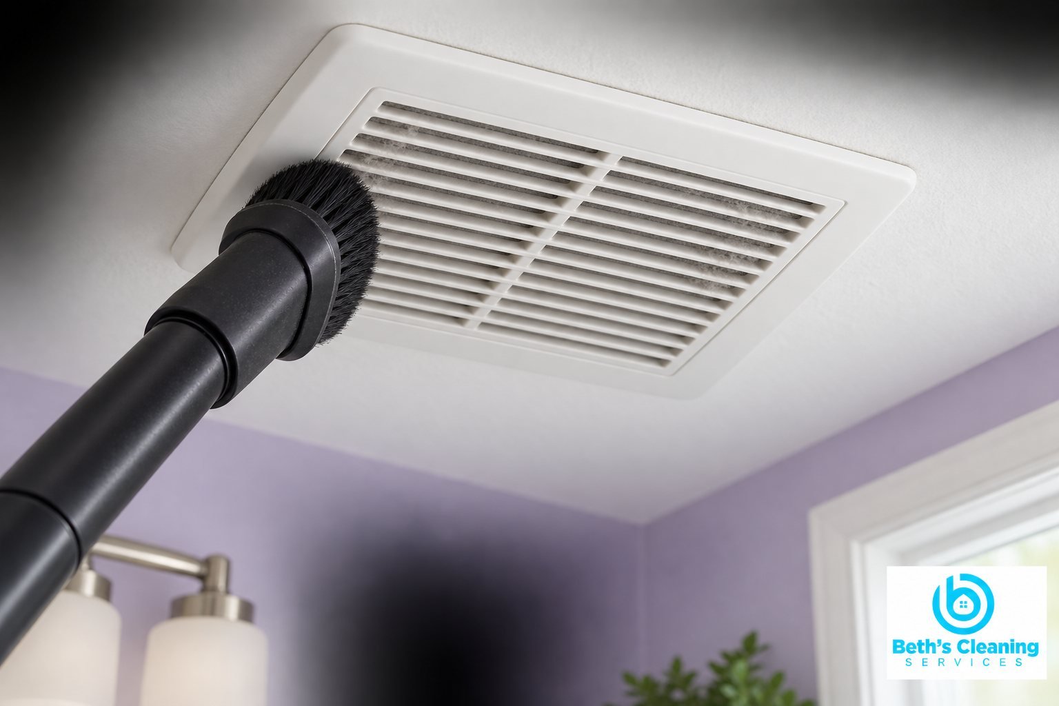 Vacuum dusting brush removing lint from a white ceiling exhaust grille in a lavender bathroom
